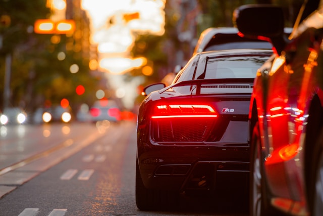 Image of the back of a car lined up in traffic on a street.