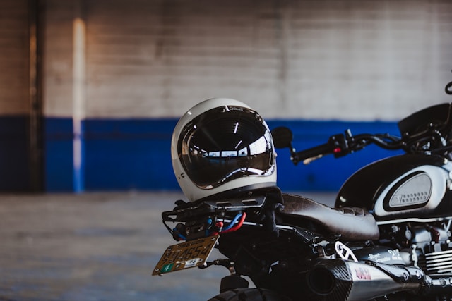 motorcycle helmet sitting on the seat of a black motorcycle.